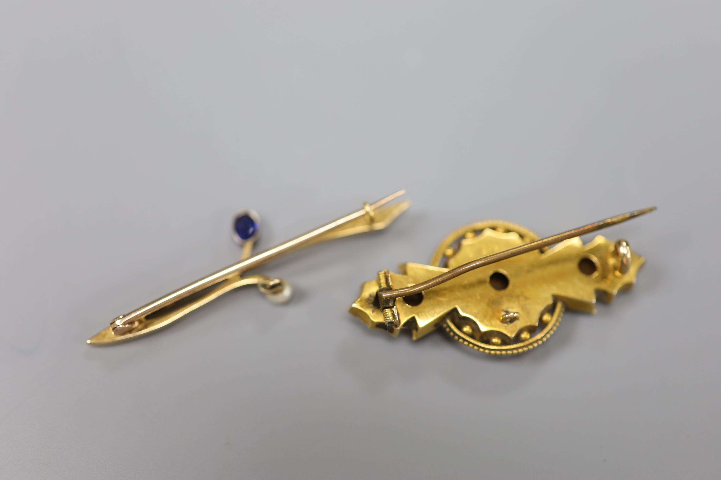 A 15ct gold, diamond and sapphire gypsy-set bar brooch and a 15ct gold foliate form pearl and sapphire set bar brooch, gross 7.5g.